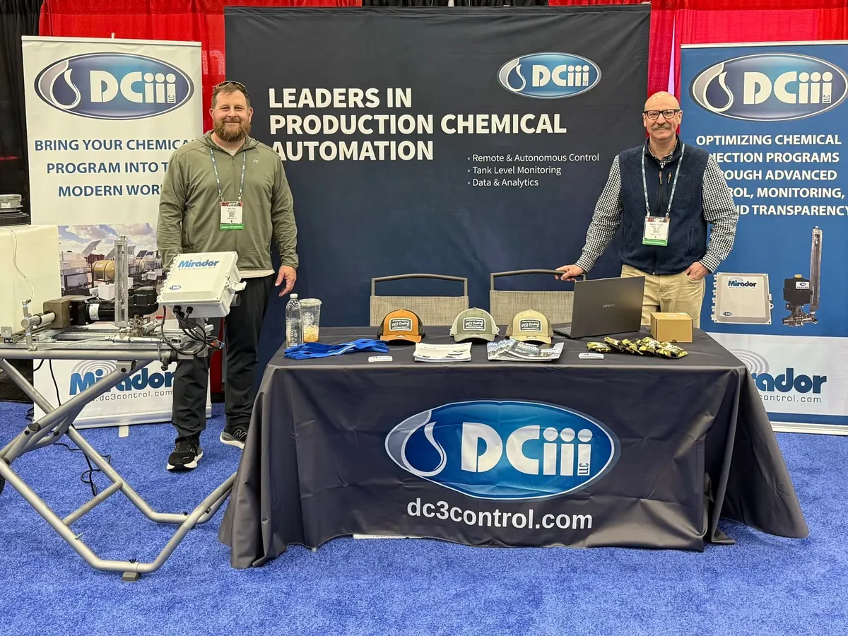 Two DC3 team members at the DCiii trade show booth with a Mirador demo unit