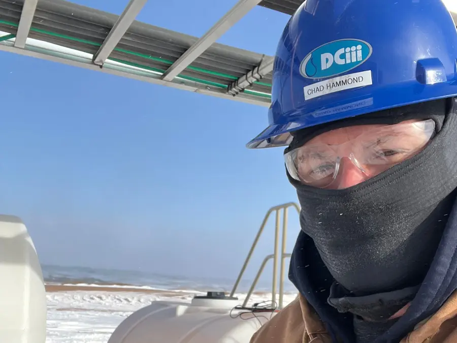 DC3 team member in a DCiii hard hat at a snowy wellsite