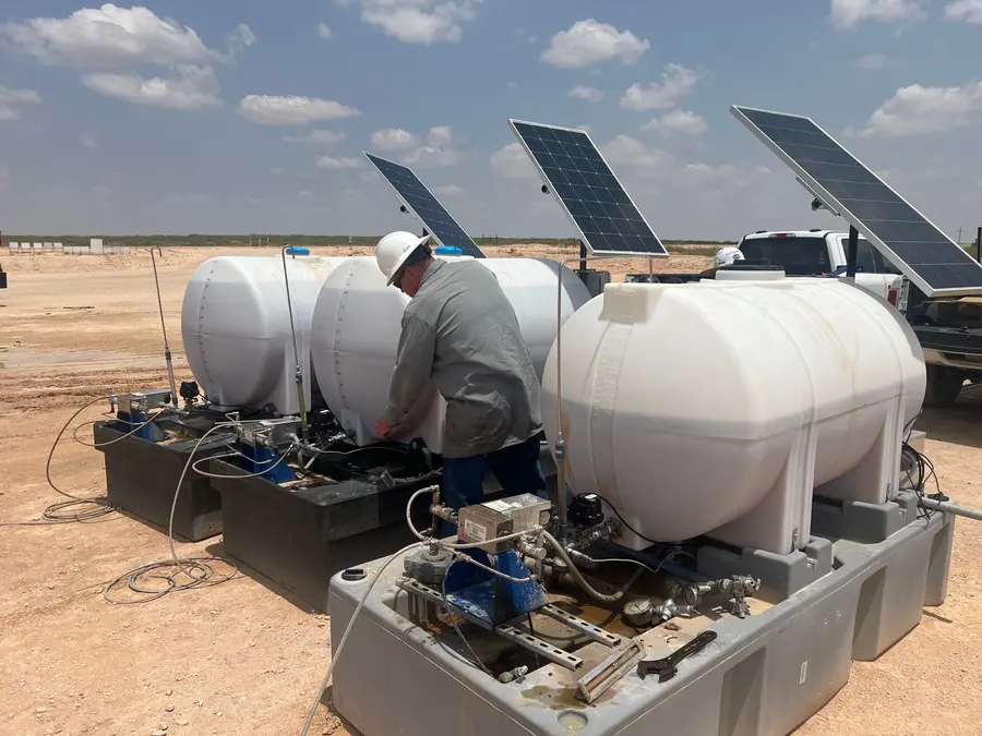 Field technician working on chemical tanks and pumps