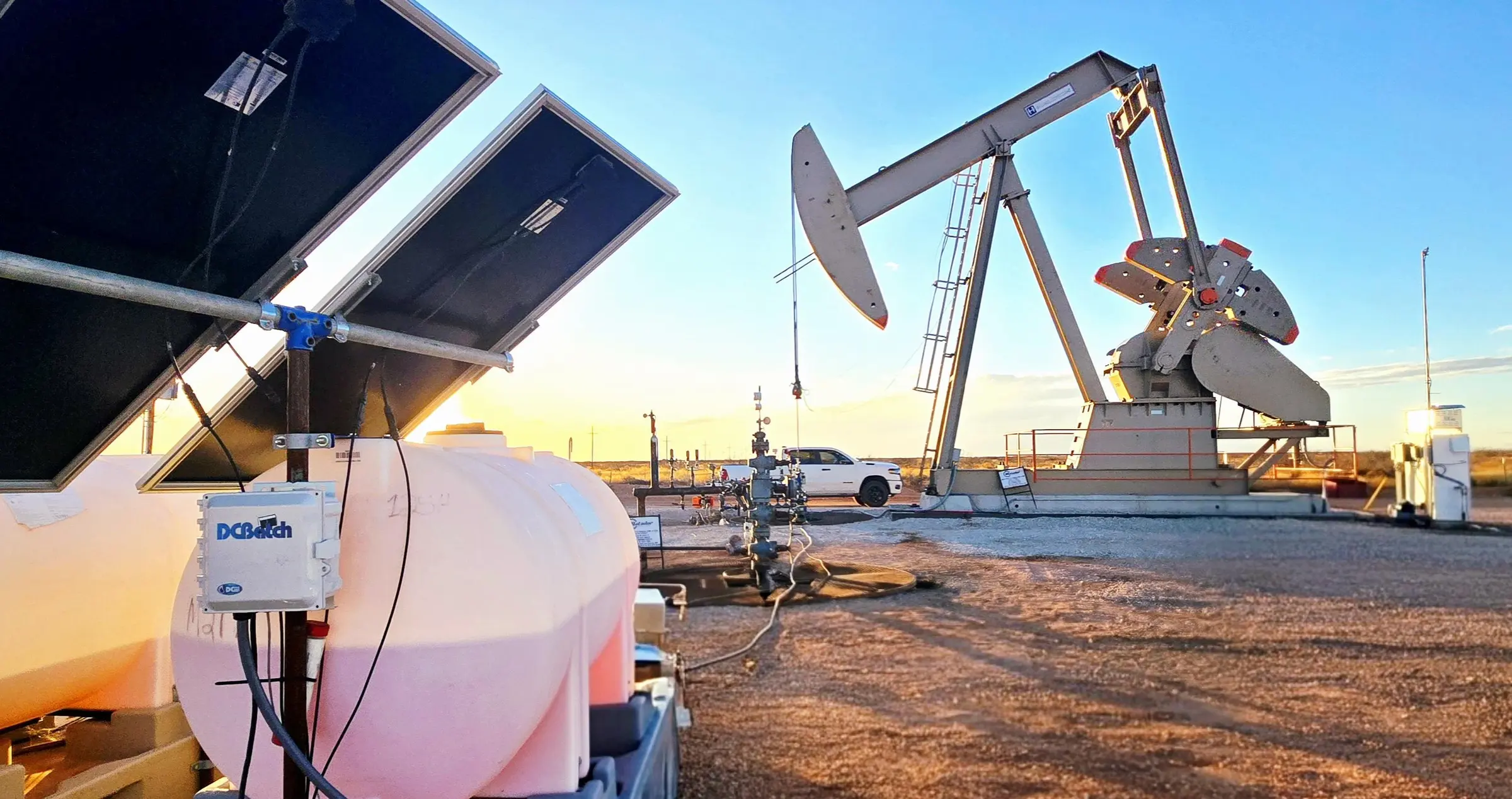 DCBatch system with solar power beside a pump jack at sunset