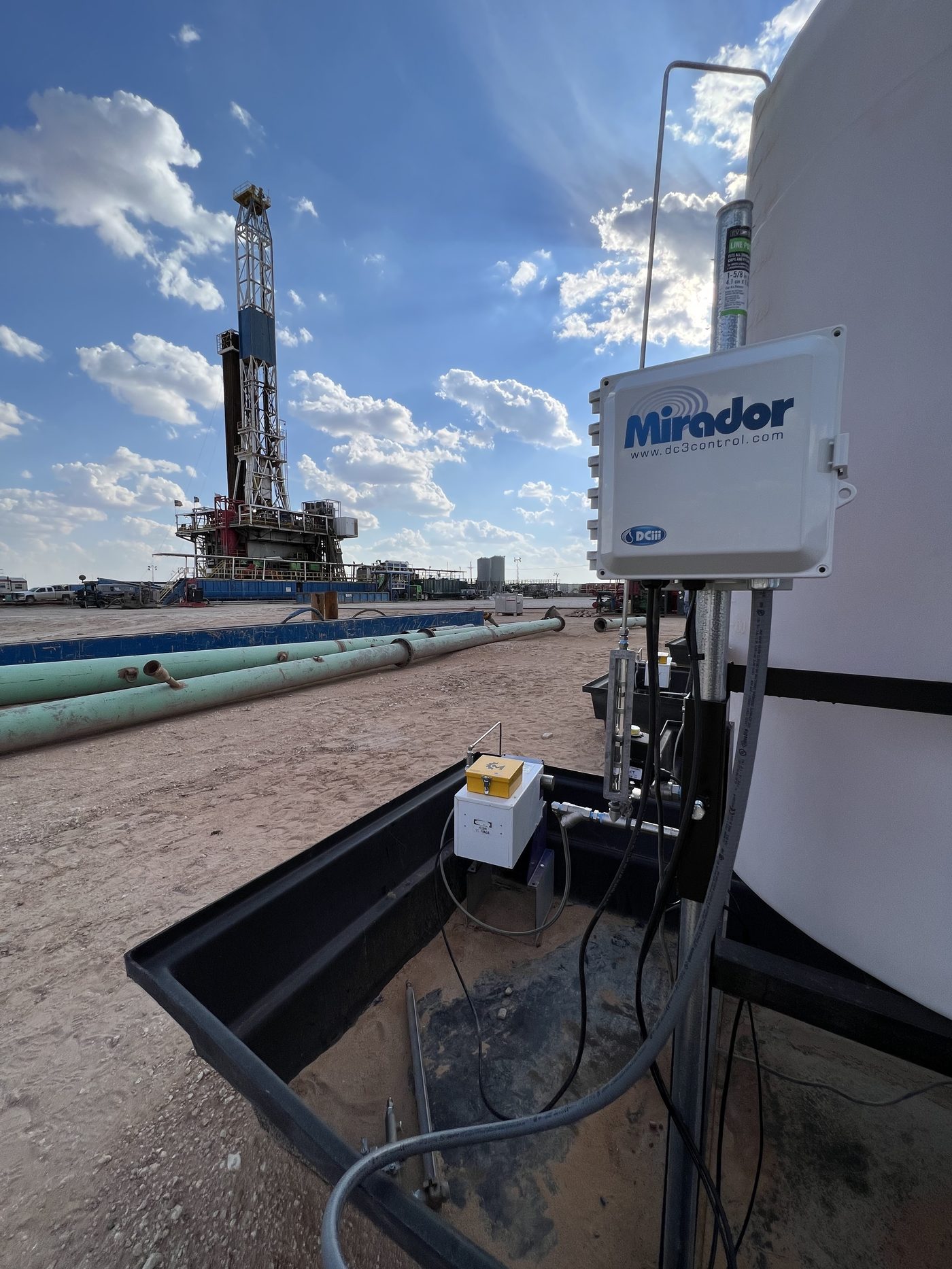 Mirador controller installed at a wellsite with drilling rig in the background
