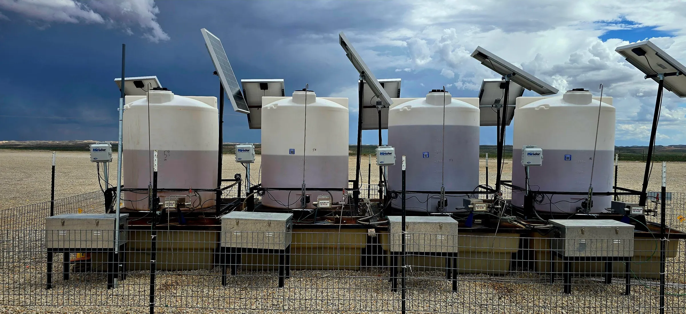 Row of solar-powered chemical injection tanks with Mirador controllers